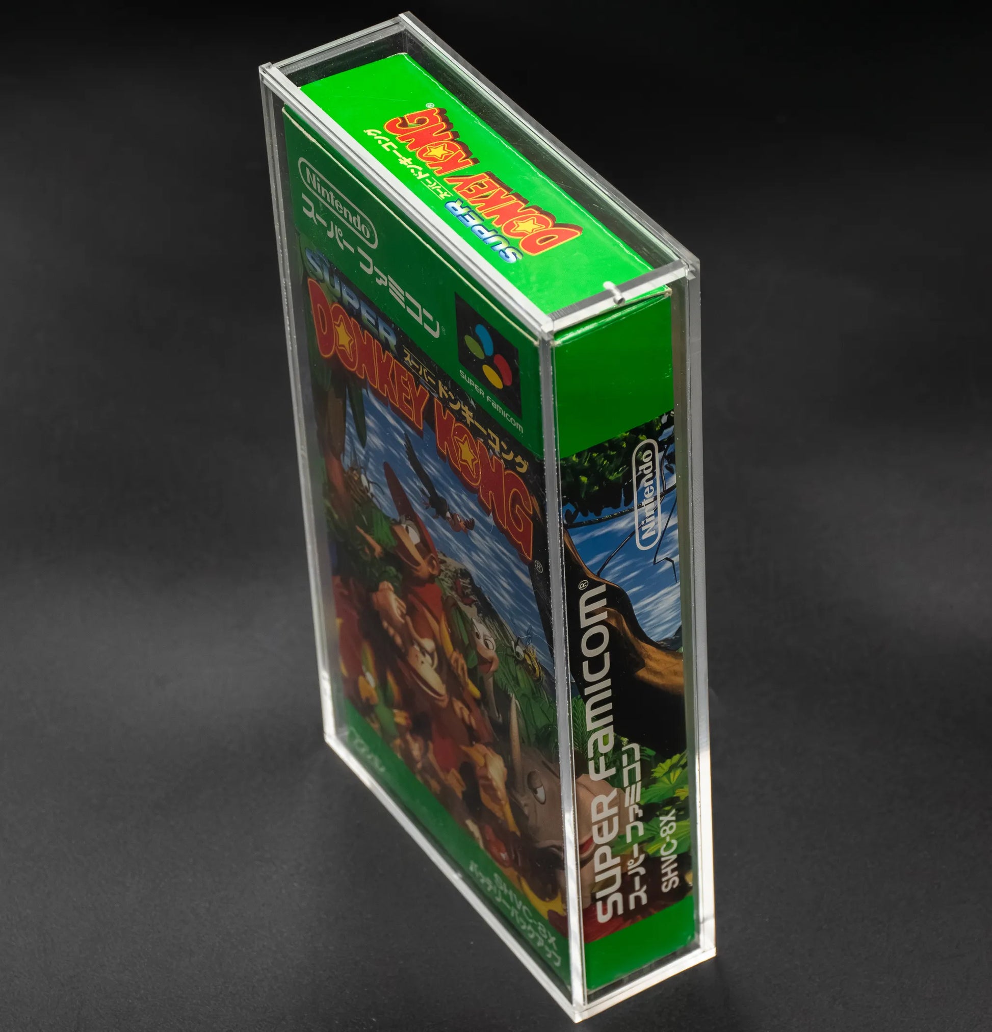 Vista lateral de caja de metacrilato con videojuego de Nintendo Super Famicom